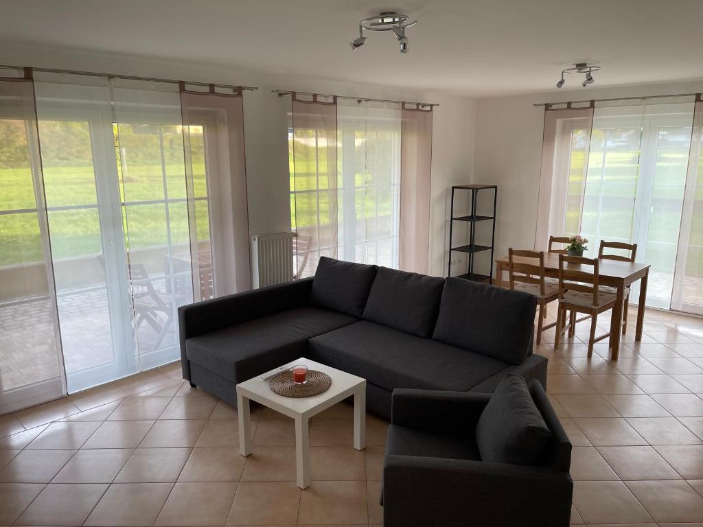 a living room with a black couch and a table at Apartment Mühlbach in Bad Abbach