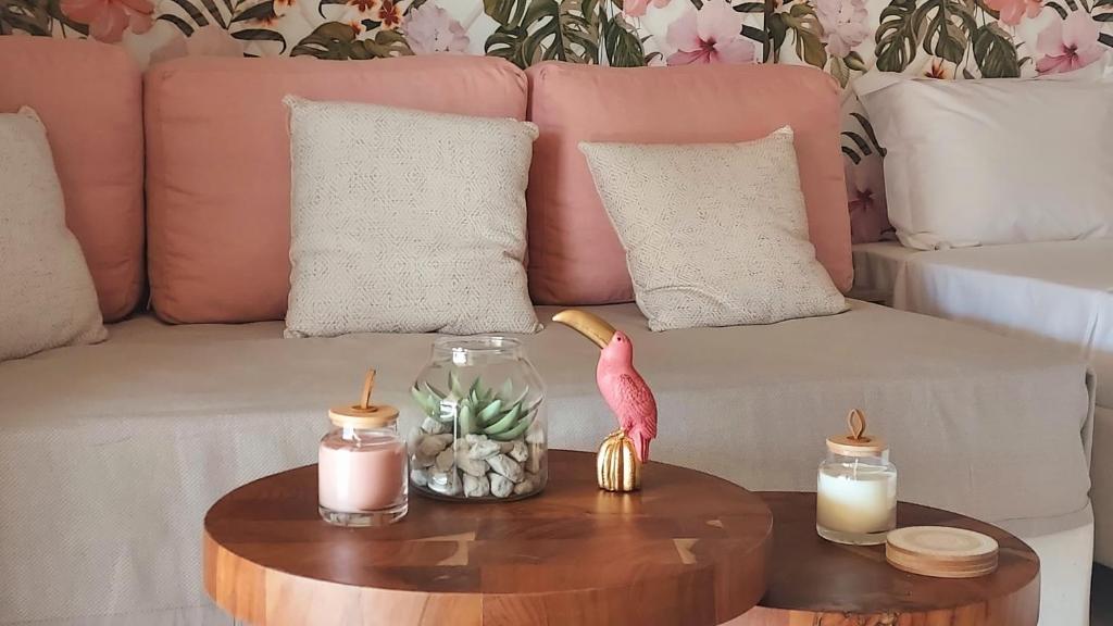 a living room with a couch with candles and a pink flamingo at Loutraki Pinky Pearl in Loutraki