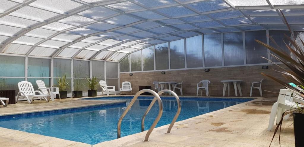 a swimming pool with a glass ceiling and a swimming pool at Rey del Bosque Apart - Hotel & Spa in Valeria del Mar