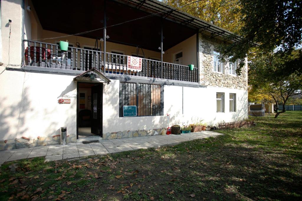 ein weißes Gebäude mit Balkon darüber in der Unterkunft Guest House Iaraji in Tʼianetʼi