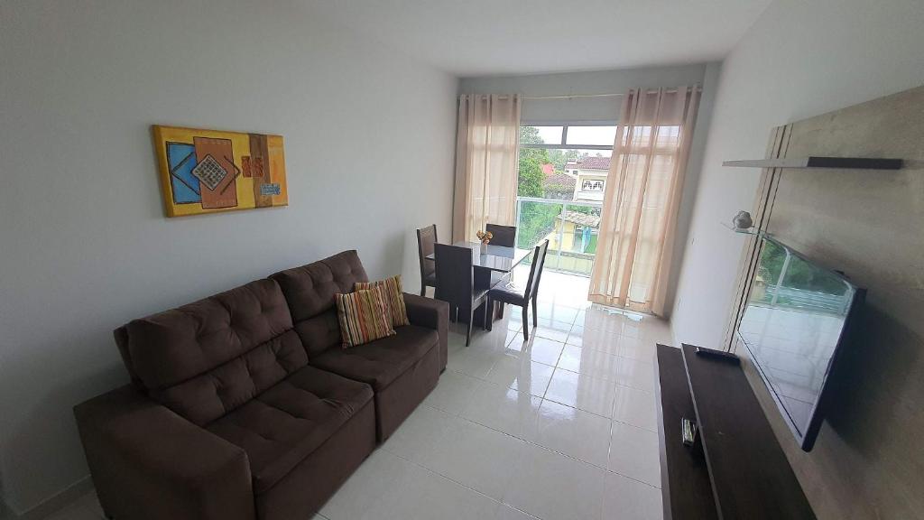 a living room with a brown couch and a table at Apto 2 Quartos I 2 Banheiros I Guarapari I Por do sol I Wi-Fi in Guarapari