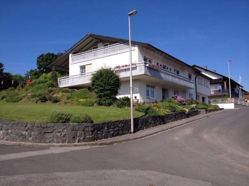 a white building with a balcony on the side of a street at Gästehaus Stapf in Oberaurach