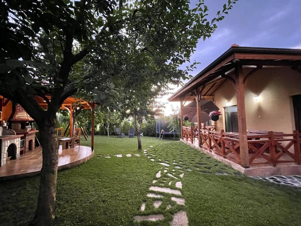 a garden with a pavilion next to a building at Guest House Marchini in Sapareva Banya
