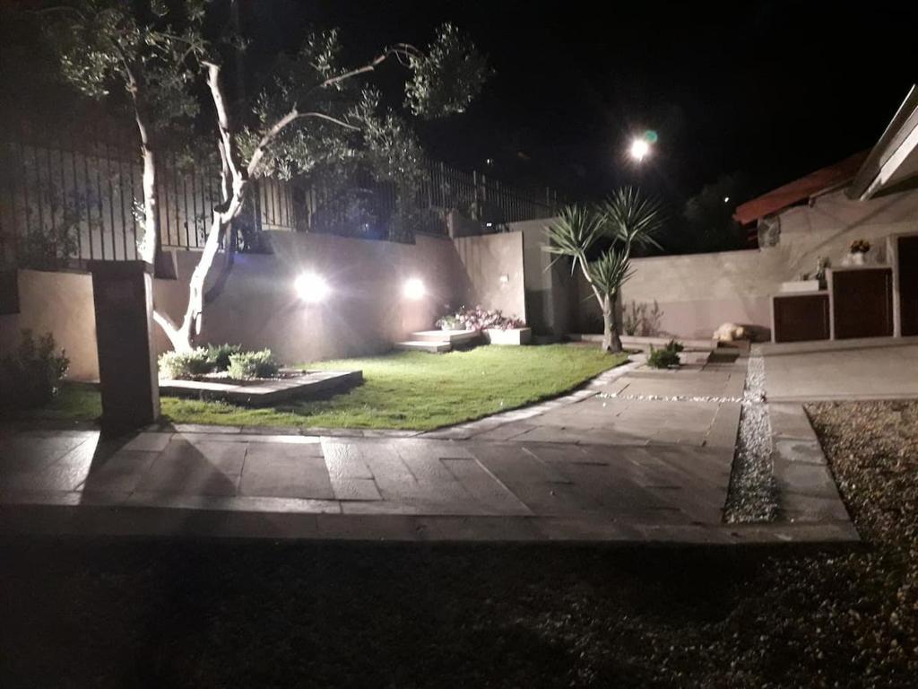 um jardim à noite com luzes numa casa em Casa vacanze Rebecca em Chia