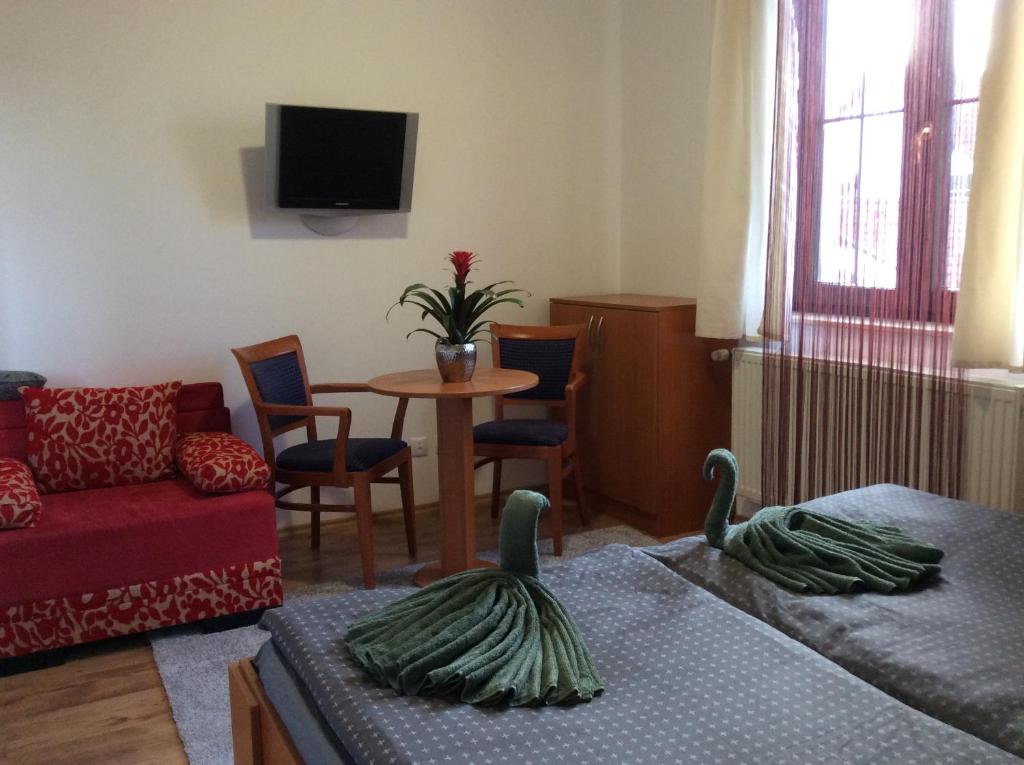 uma sala de estar com um sofá e uma mesa com cadeiras em Pension Orbis em Mariánské Lázně