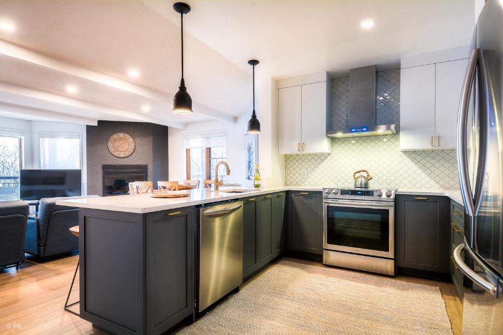 uma cozinha com armários e electrodomésticos a preto e branco em Huge 3 Bedroom Condo with a View em Mont-Tremblant