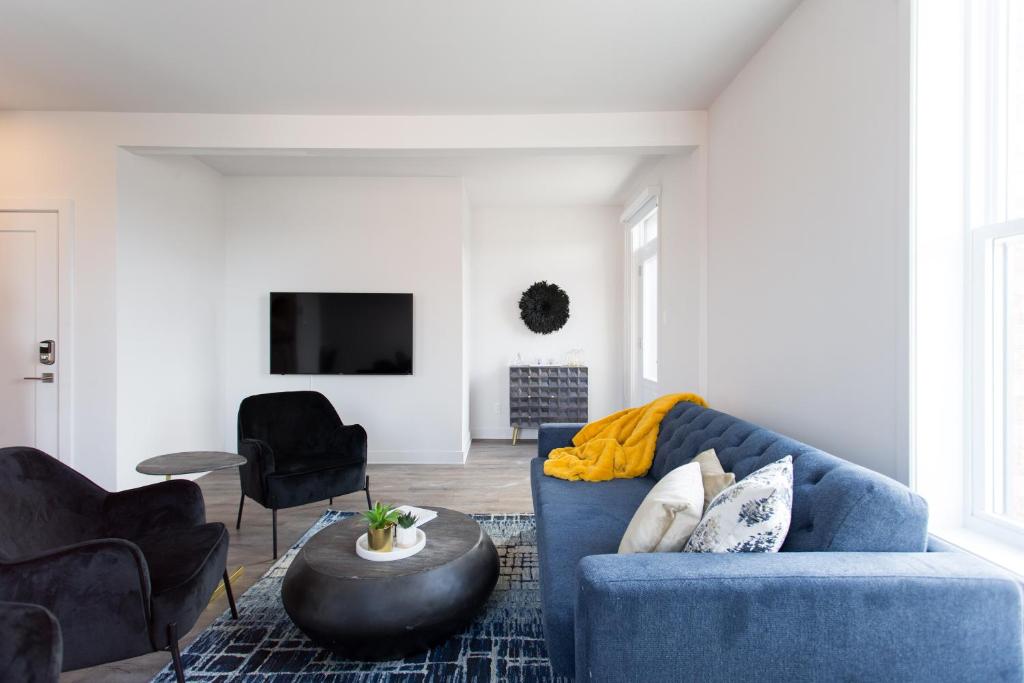 a living room with a blue couch and a table at Stunning 1 Bedroom in Mile End by Den Stays in Montréal