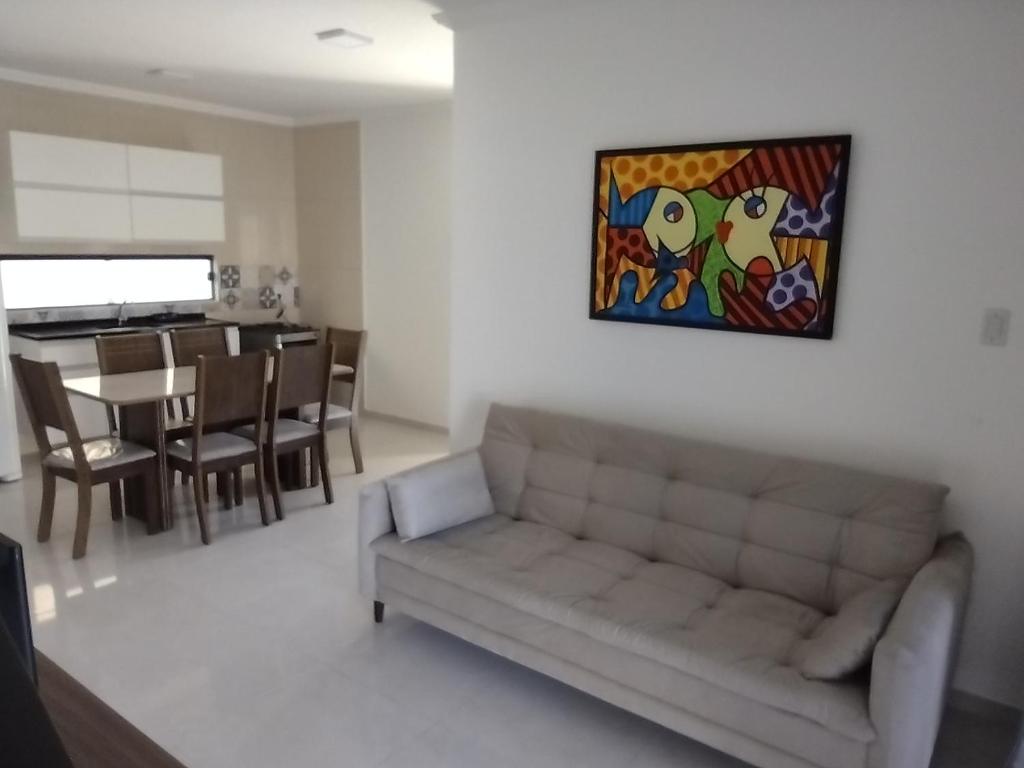 a living room with a couch and a painting on the wall at Residencial Secret Point in Praia do Frances