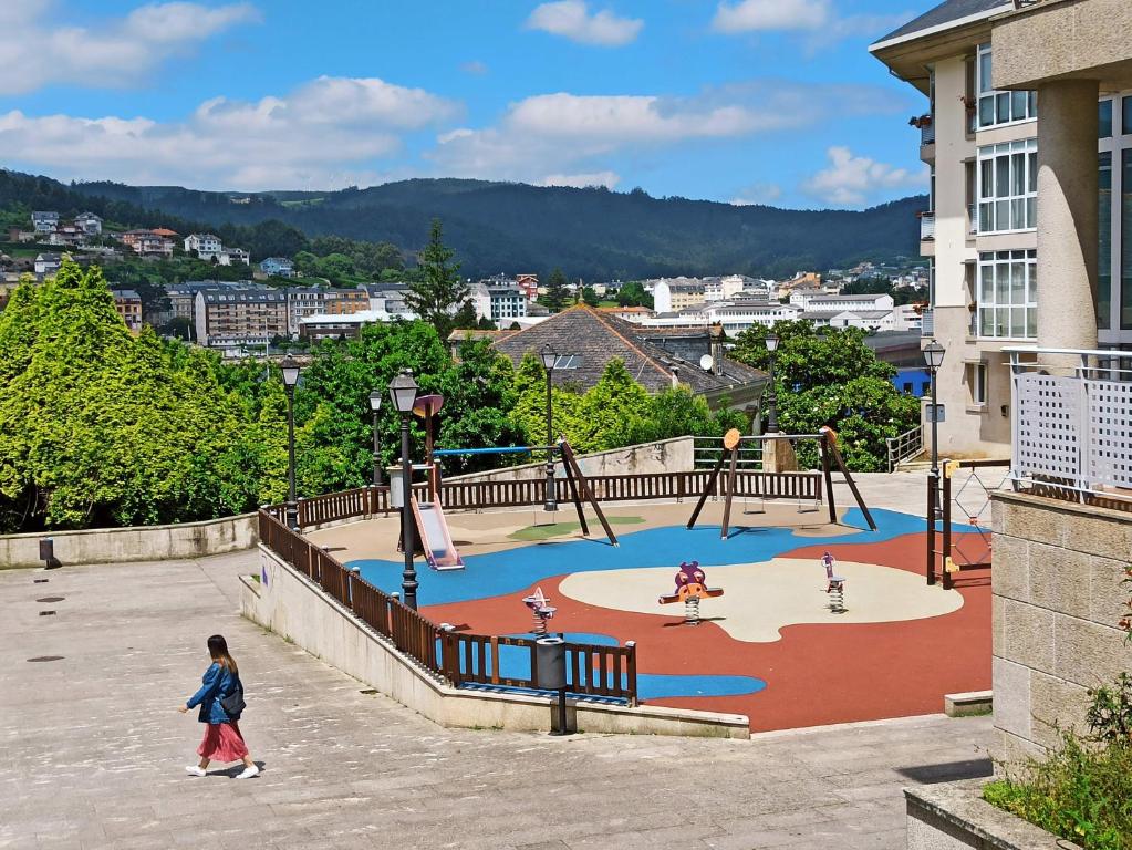 a child walking around a playground in a city at Viveiro Histórico 3 in Viveiro