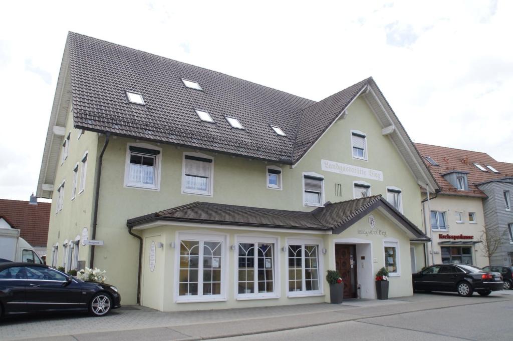 uma grande casa amarela com um telhado preto em Sonnenhalde Landgasthof Bieg em Neuler
