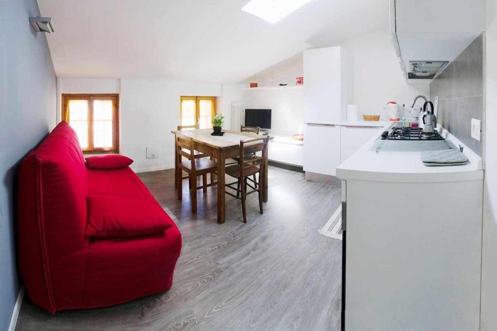a kitchen with a red couch and a red chair at Relax Suite Holiday Apartment in Riva del Garda