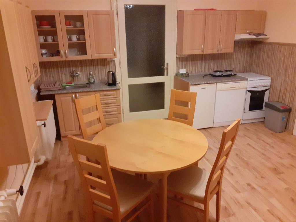 a small kitchen with a wooden table and chairs at Apartmán se zahradou kousek od Ještědu in Liberec