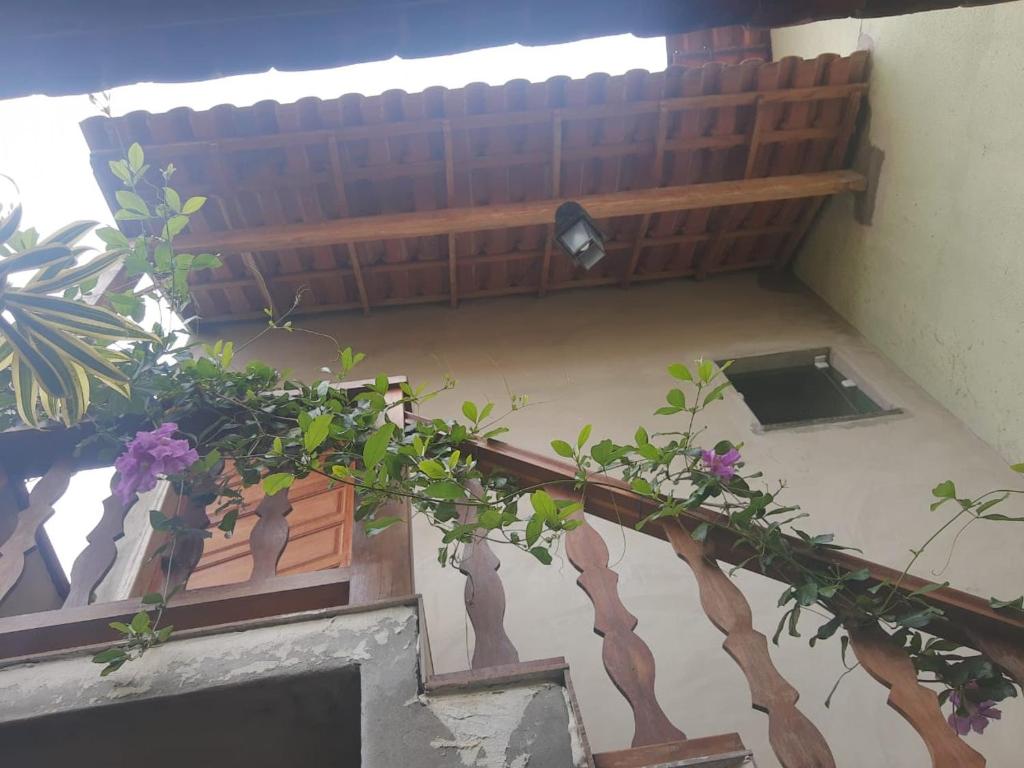 a building with a balcony with flowers on it at Suíte Verde in São Pedro da Aldeia