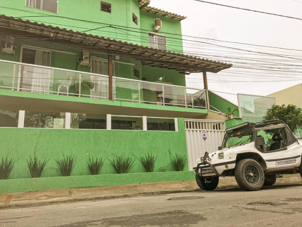 ein weißer Jeep, der vor einem grünen Gebäude parkt in der Unterkunft Pousada Caminho dos Anjos in Arraial do Cabo