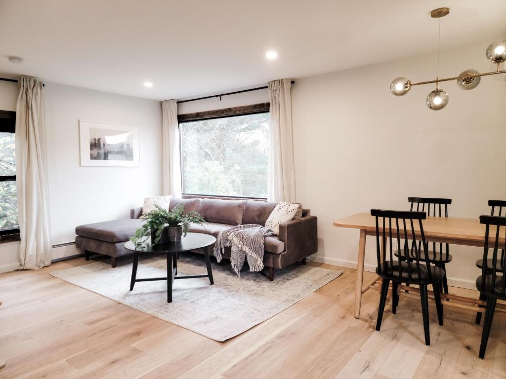 een woonkamer met een bank en een tafel bij Black Pearl Unit 2 - Lake Placid, Mirror Lake in Lake Placid