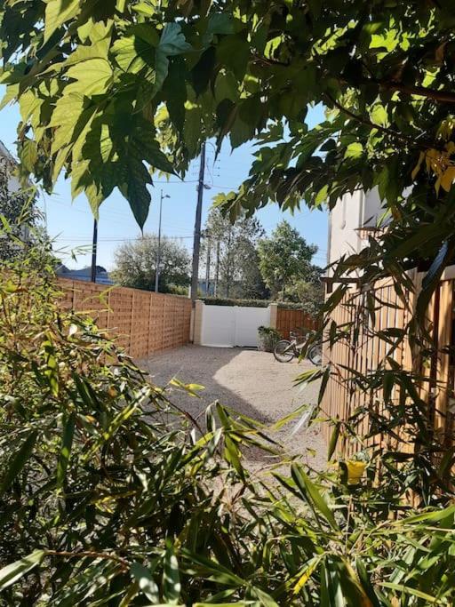 a backyard with a fence and a brick wall at Un jardin en ville in Talence