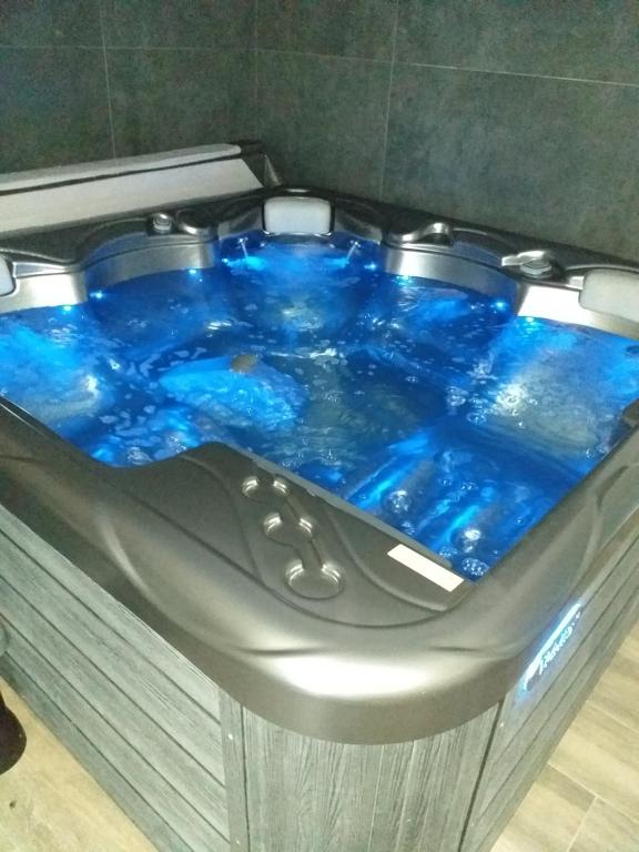 e bagno con vasca idromassaggio con acqua blu. di La belle grange a Saint-Étienne-au-Mont