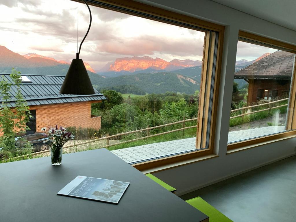 Cette chambre dispose d'une table et d'une fenêtre avec vue. dans l'établissement Bregenzerwaldblick, à Schwarzenberg im Bregenzerwald