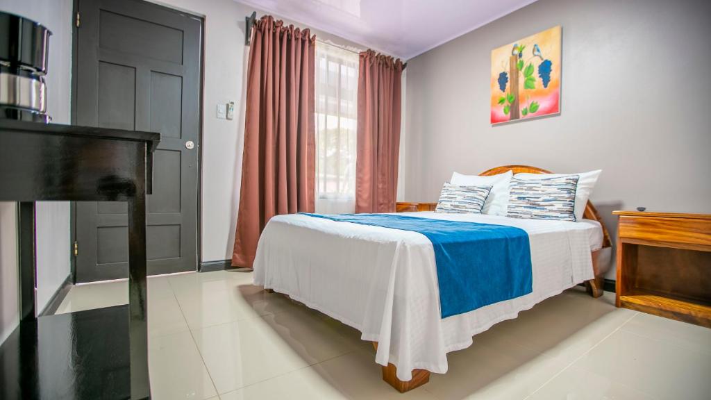 a bedroom with a bed and a television at Hotel La Vid La Fortuna in Fortuna