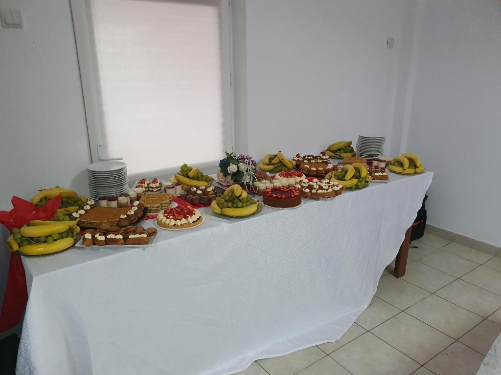 a table filled with different types of cakes and desserts at PENSIUNEA ANAIS in Cîmpeni