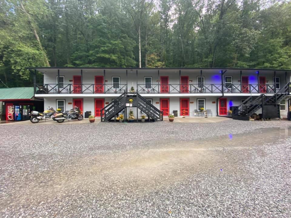 un grand bâtiment blanc avec des portes rouges et des motos garées devant dans l'établissement Dragon City, à Maryville