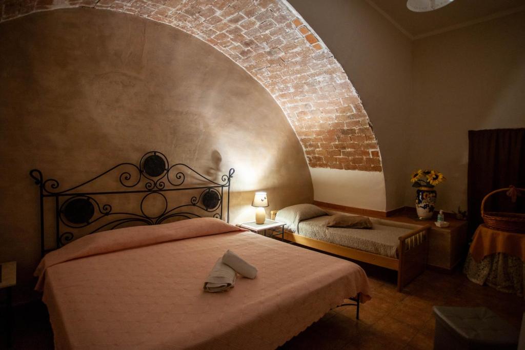 a bedroom with a bed and a brick wall at CASA VACANZE FONDACO DI SCILLATO in Scillato