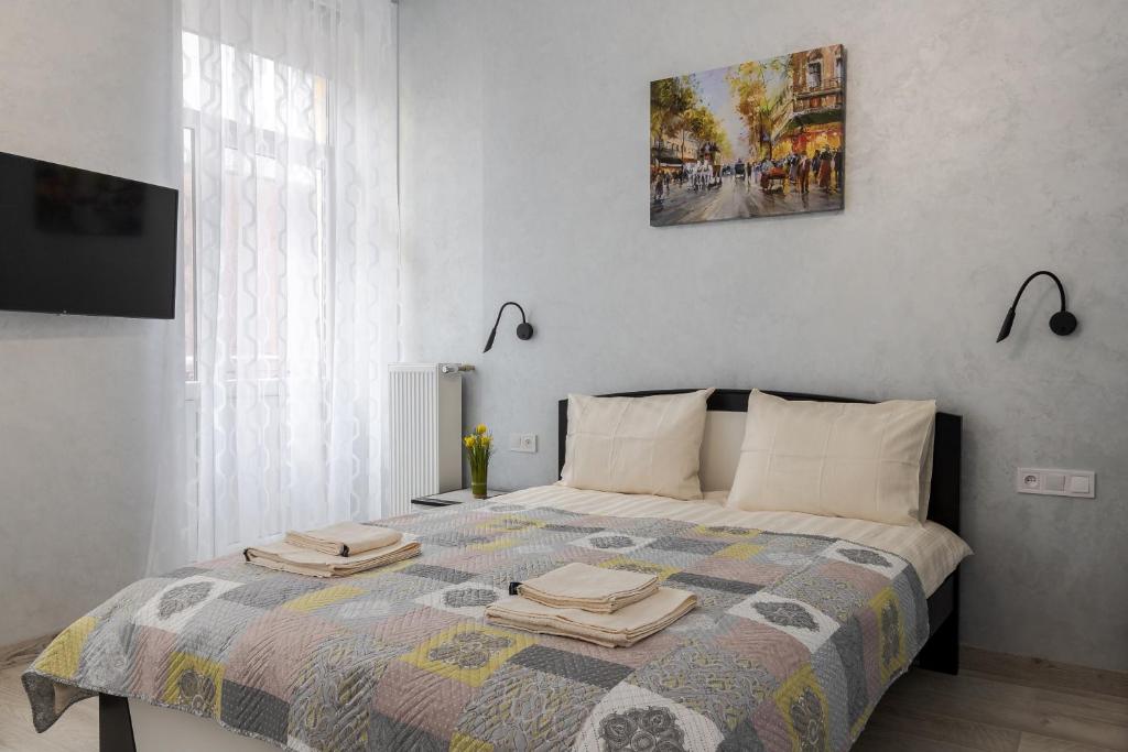 Un dormitorio con una cama con dos toallas encima. en Golden Violin ! Apartments Lviv S, en Leópolis