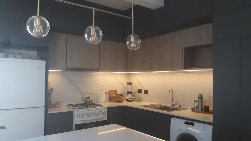 a kitchen with a stove and a white refrigerator at Lugar confortable y tranquilo in Patagones