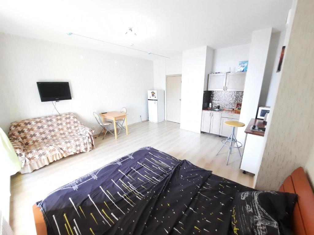 a large living room with a bed and a kitchen at K&K Apartments Gulliver 468 in Perm