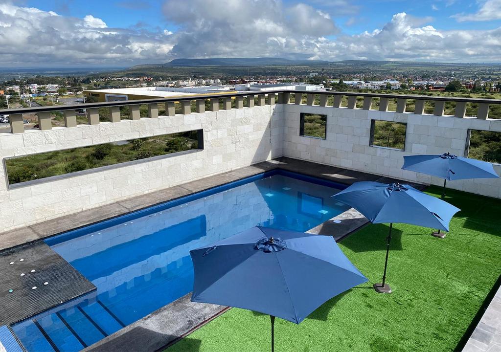 
a blue umbrella sitting on top of a green lawn at Hotel MX San Miguel de Allende in San Miguel de Allende
