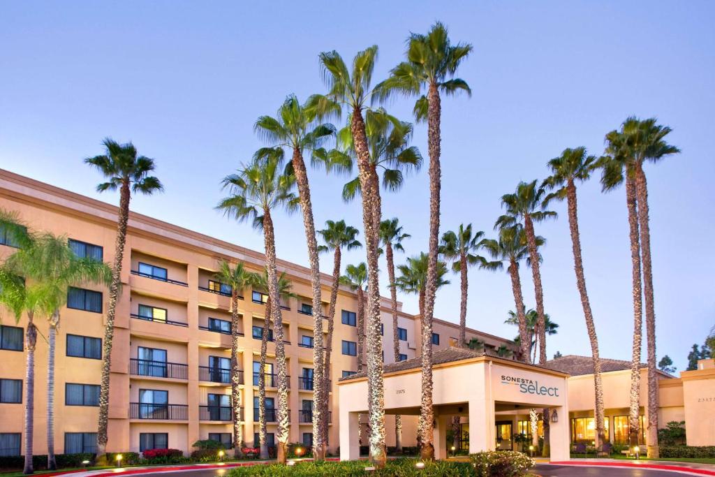 a hotel with palm trees in front of it at Sonesta Select Laguna Hills Irvine Spectrum in Laguna Hills