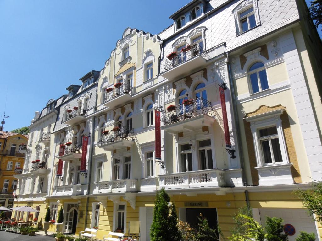 een groot wit gebouw met ramen en balkons bij Residence Romanza in Mariánské Lázně