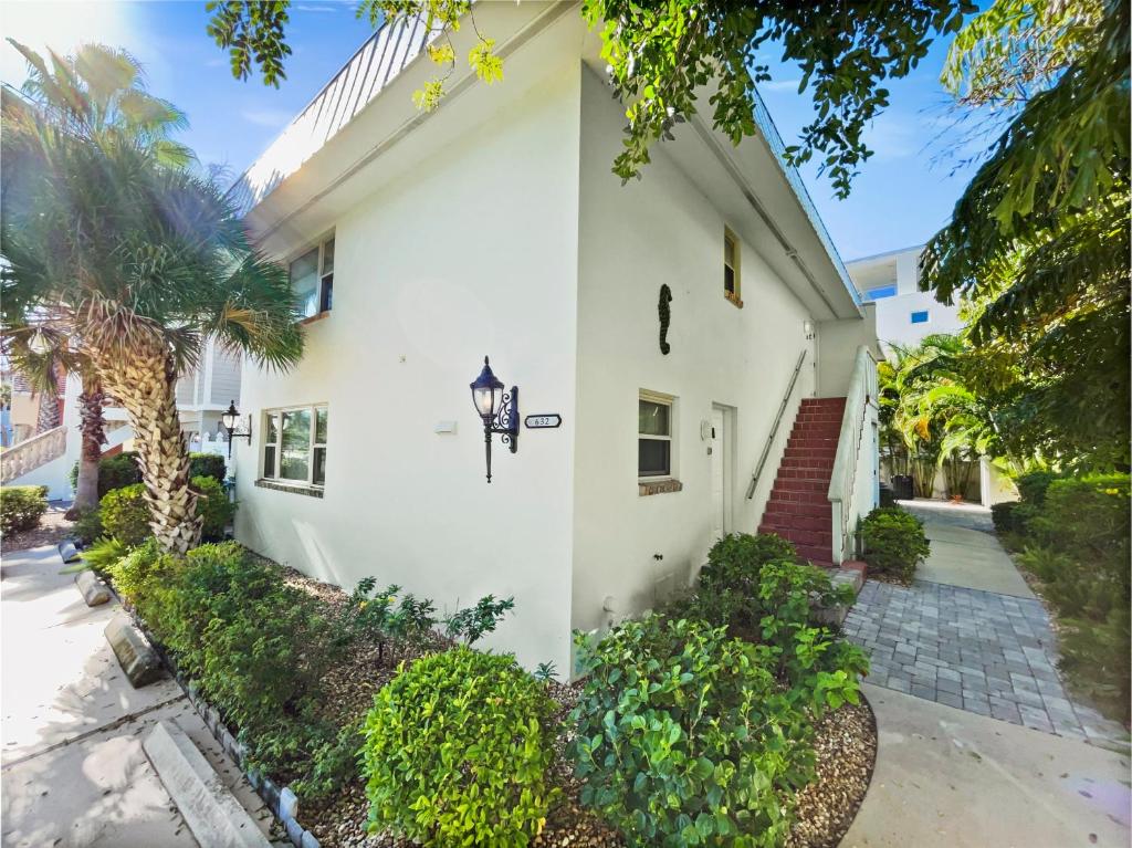 a white house with a palm tree in front of it at Newly Fully Updated and Modern, Short Walk to BEACH in Siesta Key