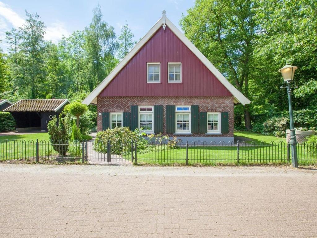 MeddooにあるSnug holiday home in Winterswijk Meddo with a private gardenの赤と緑の家