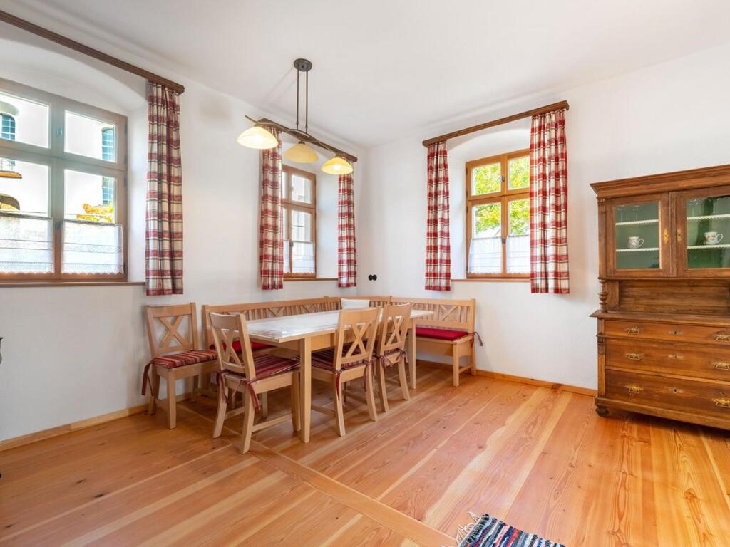 een eetkamer met een tafel, stoelen en ramen bij Holiday home in the Upper Palatinate Forest in Neunburg vorm Wald
