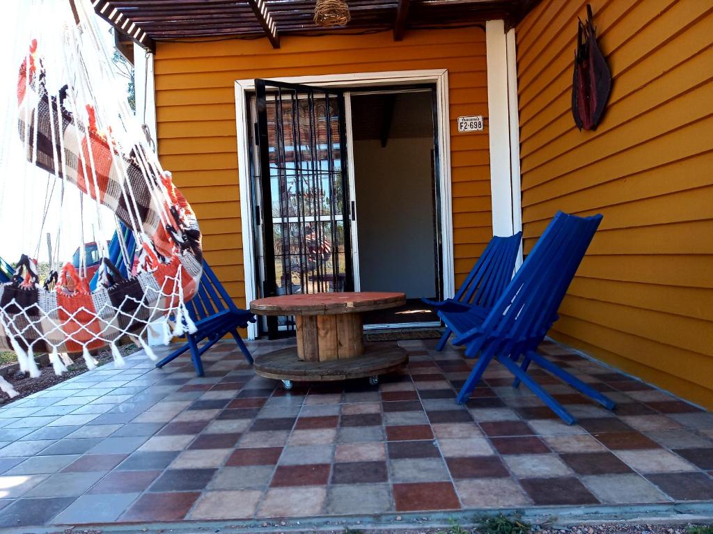 2 blaue Stühle und ein Tisch auf der Veranda in der Unterkunft Viudita del Diablo in Punta Del Diablo