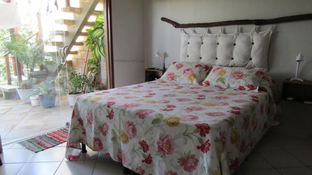 a bedroom with a large bed with a red and white blanket at Brisas do Amor 131 in Pipa