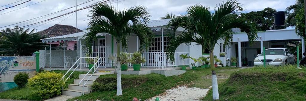 una casa con palmeras delante en Posada Caribbean Refuge, en San Andrés