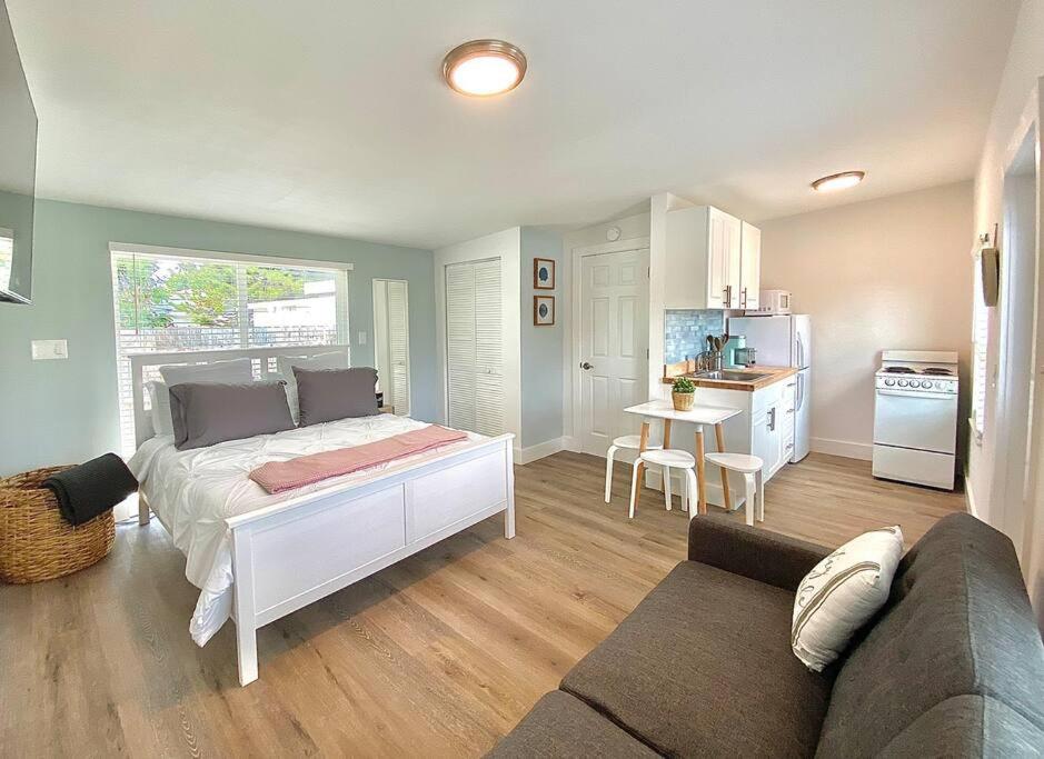 a bedroom with a bed and a kitchen with a couch at Cute Tiny House w Private Plunge Pool near Beach in Delray Beach