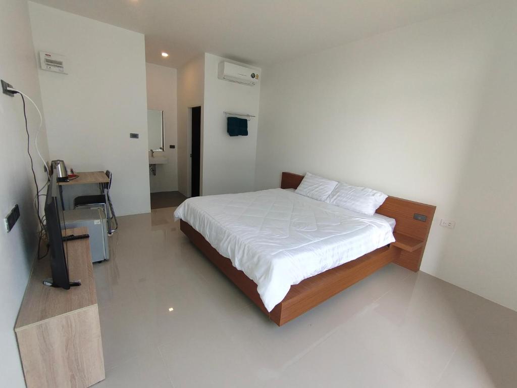 ATTITUDE THE RESORT في ناخون راتشاسيما: غرفة نوم مع سرير مع ملاءات بيضاء ومكتب