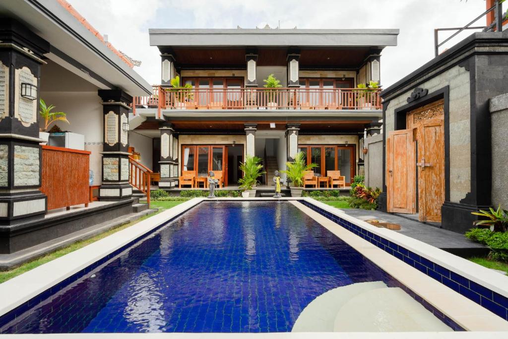 uma villa com piscina em frente a uma casa em Prama Beach Canggu by The Loka em Canggu