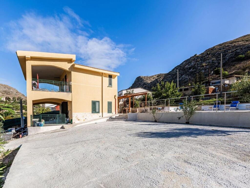 a house with a large driveway in front of a mountain at Apartment, Sicily with Terrace in Realmonte