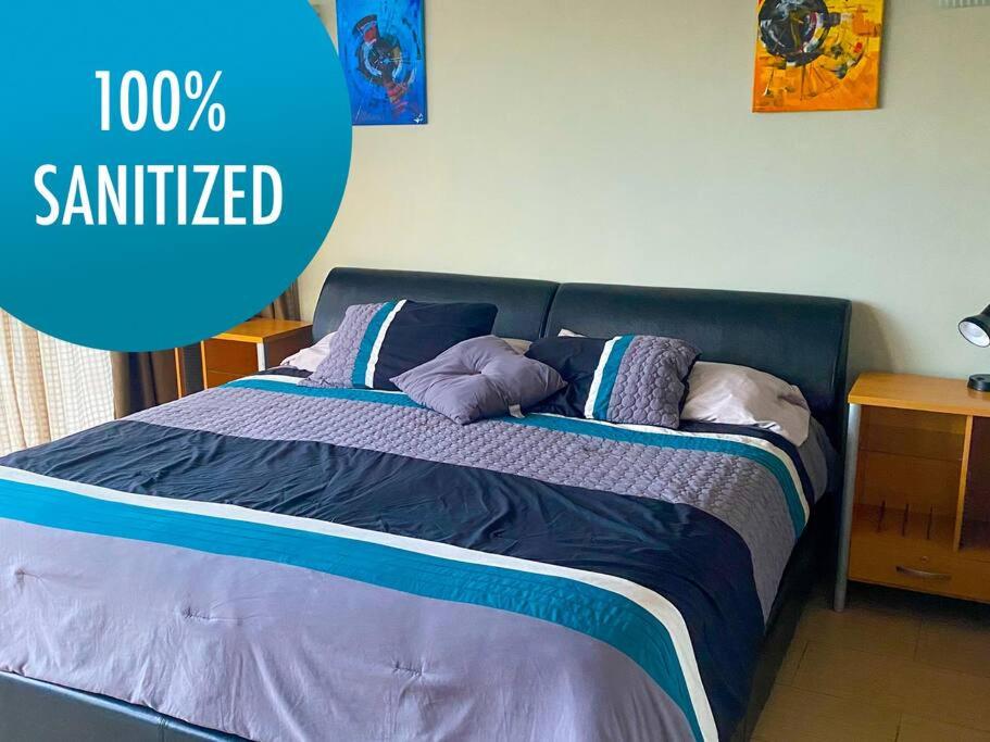 Una cama en un dormitorio con una señal azul que se aserraba en 2 Rooms, 1 King Size bed, 64" Smart HDTV, en Guatemala