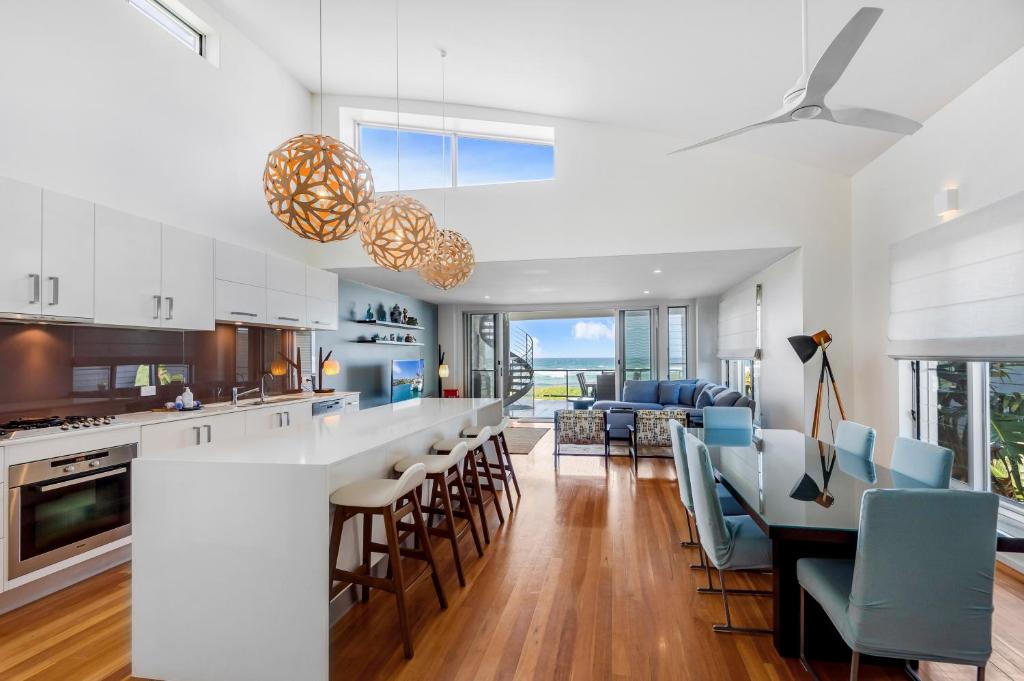 a kitchen and living room with a table and chairs at Costa del Sol - Beachfront Lennox Head in Lennox Head
