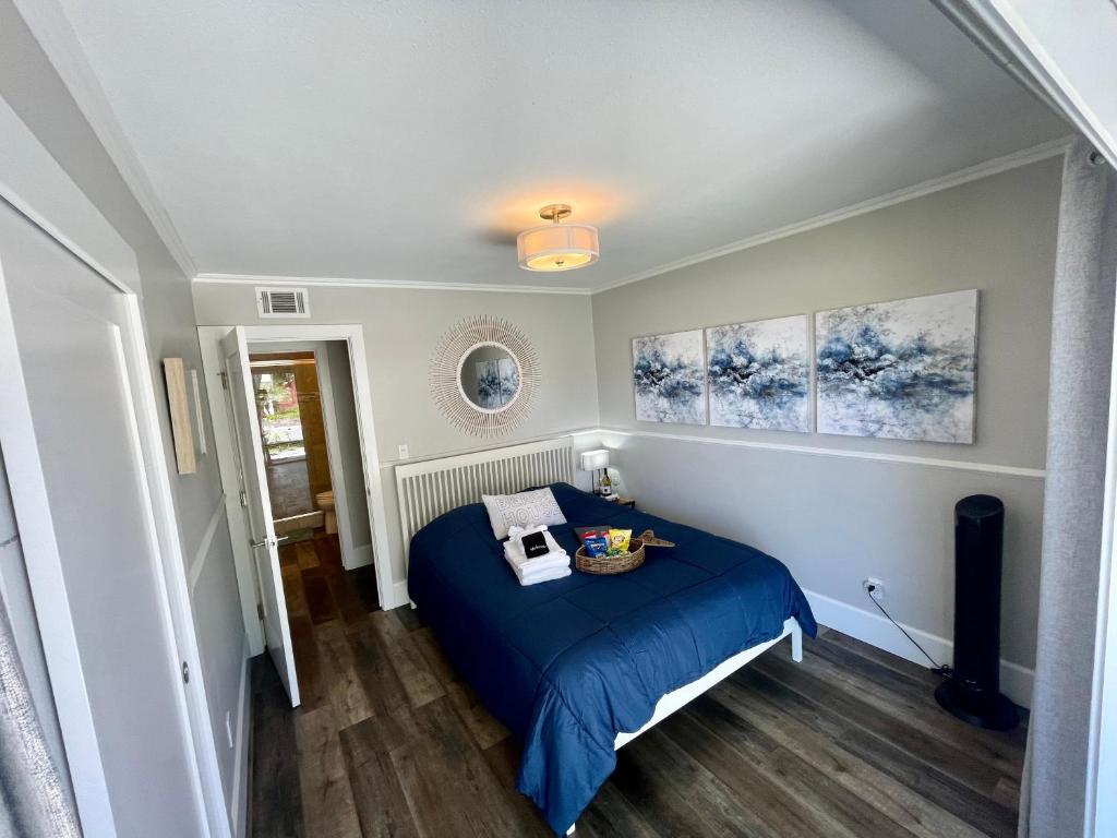 a bedroom with a blue bed and paintings on the wall at Lovely Del Mar retreat private entrance 1 bd 1ba in San Diego