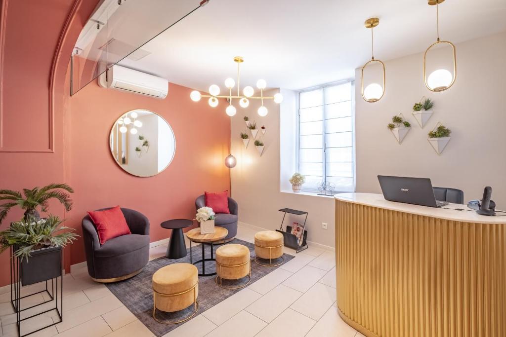 a waiting room with a counter and chairs and a laptop at Hôtel Le Seize, Nice Centre in Nice