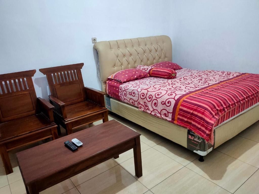 um quarto com uma cama, duas cadeiras e uma mesa em Hotel Arjuna Sari Bandungan em Bandungan