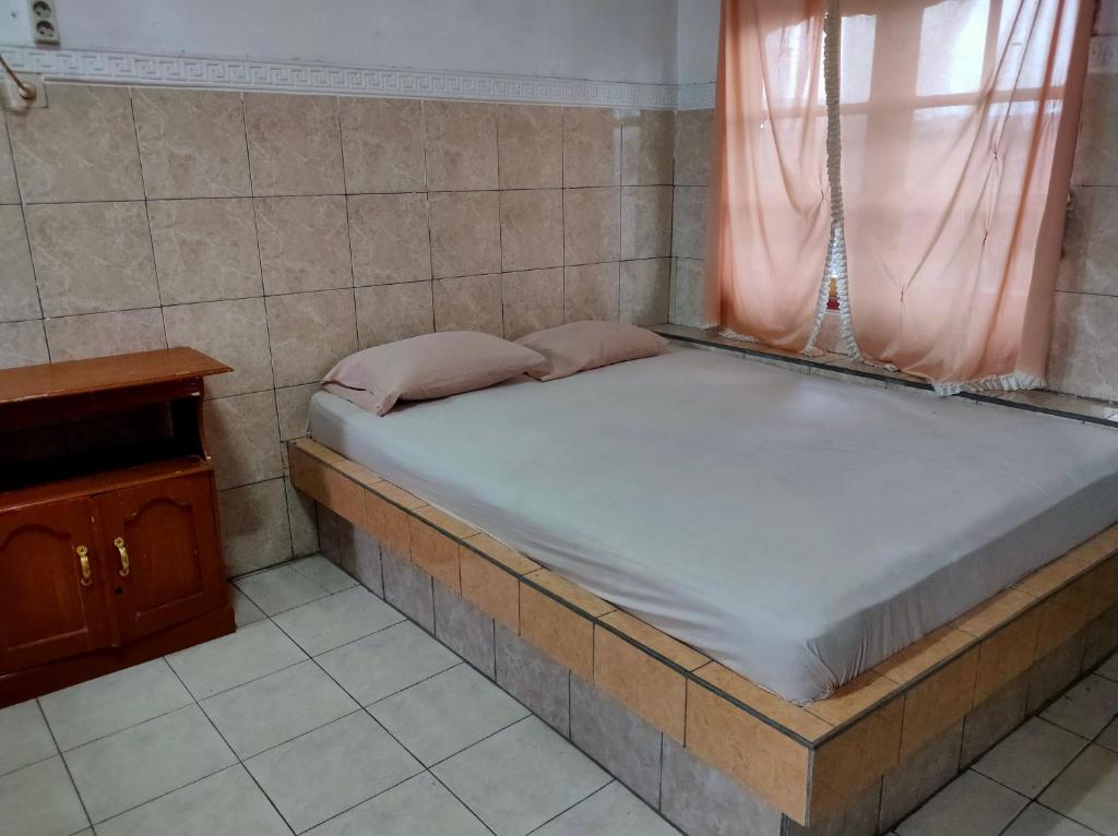 Uma cama ou camas num quarto em Hotel Arjuna Sari Bandungan