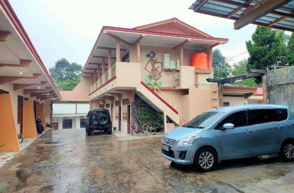 uma carrinha azul estacionada em frente a um edifício em Hotel Arjuna Sari Bandungan em Bandungan