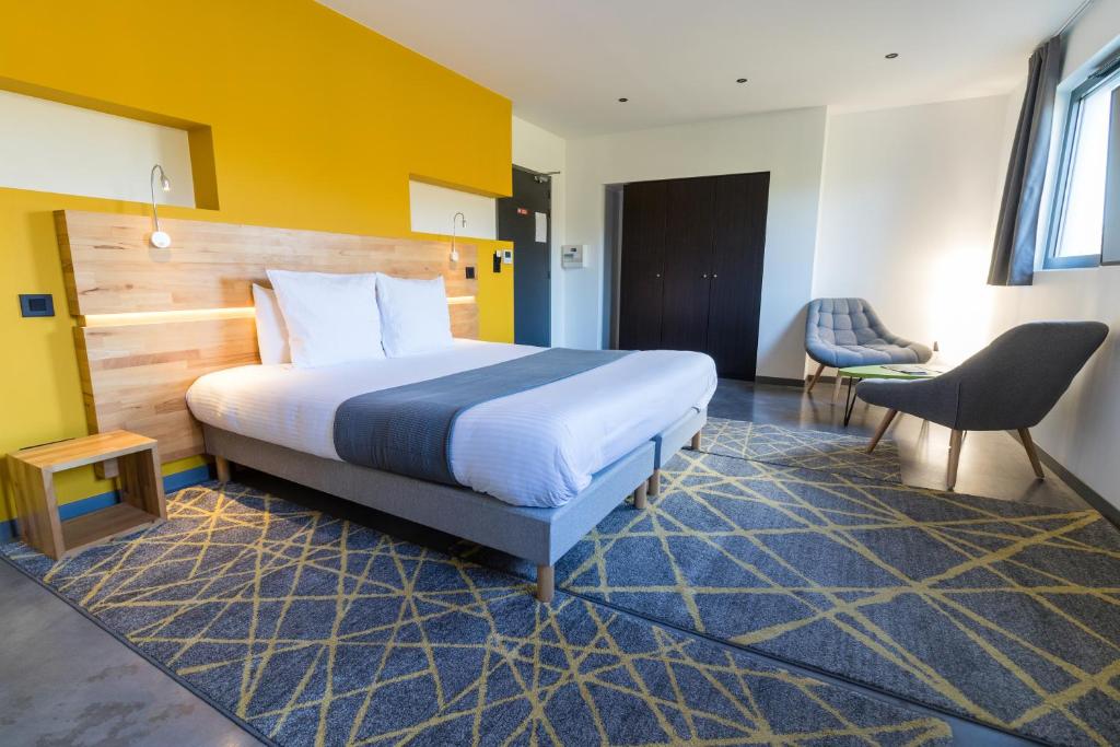 ein Hotelzimmer mit einem Bett und einem Stuhl in der Unterkunft H85 in Chatte